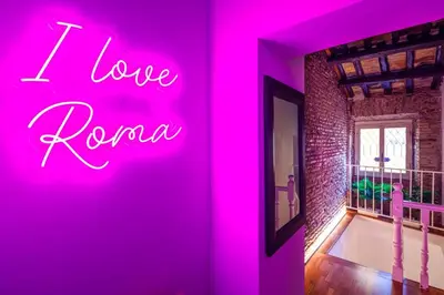 a neon sign that says i love roma on a wall at Romanticasa Trastevere in Rome