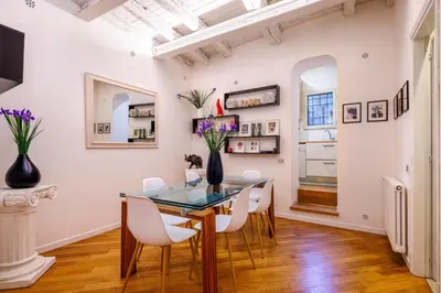 a dining room with a glass table and white chairs at Romanticasa Trastevere in Rome