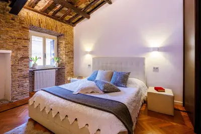 a bedroom with a bed and a brick wall at Romanticasa Trastevere in Rome