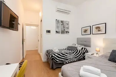 a small room with two beds and a television at Julius Caesar Home in Rome