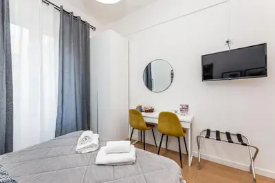 a bedroom with a bed and a table and chairs at Julius Caesar Home in Rome