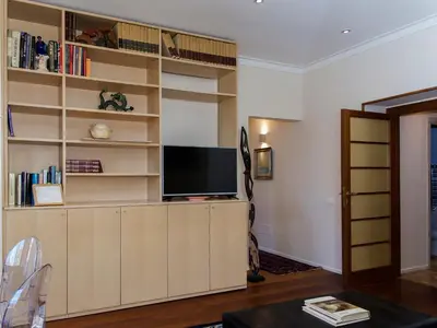 a living room with a large wooden entertainment center with a flat screen tv at The Apartments - Vatican in Rome