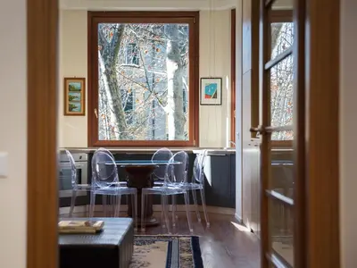 a dining room with a table and chairs and a window at The Apartments - Vatican in Rome