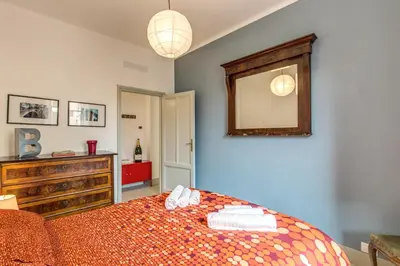 a bedroom with a bed and a dresser and a mirror at Monti Coliseum Apartment in Rome