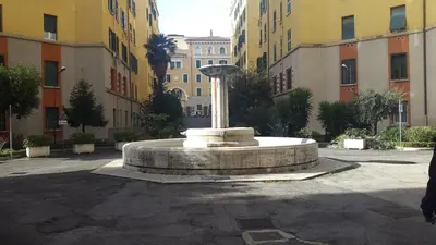 a fountain in the middle of a courtyard with buildings at Underground Rome's Room in Rome