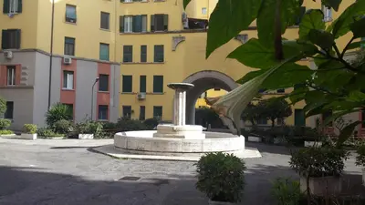 a fountain in a courtyard in front of a building at Underground Rome's Room in Rome