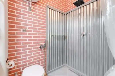 a bathroom with a shower with a brick wall at Moonlight Inn Guesthouse in Rome