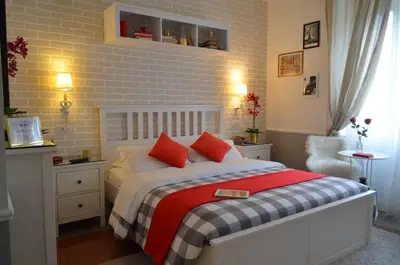 a bedroom with a bed with red pillows at Moonlight Inn Guesthouse in Rome