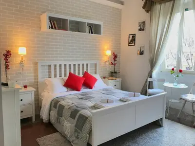 a bedroom with a white bed with red pillows at Moonlight Inn Guesthouse in Rome