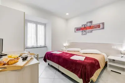 a white bedroom with a bed and a table with bread at Wonderful Time Rome in Rome