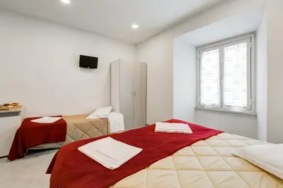 a white room with two beds and a window at Wonderful Time Rome in Rome