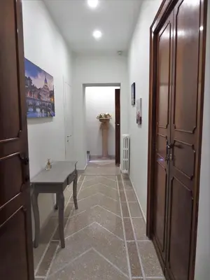 a hallway with a wooden door and a bench at 325 Rooms ai Fori in Rome