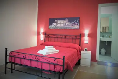 a red bedroom with a red bed with red sheets at 325 Rooms ai Fori in Rome