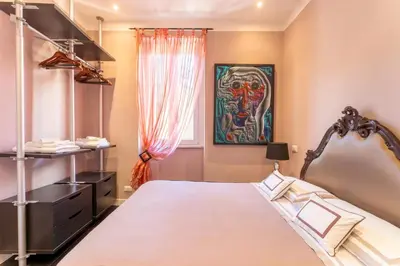 a bedroom with a bed and a painting on the wall at Atmosphera Trastevere, Glamour apartment in the center in Rome