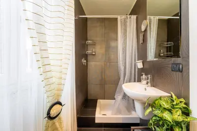 a bathroom with a sink and a shower curtain at Atmosphera Trastevere, Glamour apartment in the center in Rome
