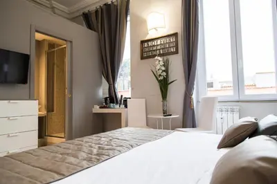 a bedroom with a large white bed and a television at Corso Experience in Rome