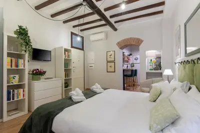 a bedroom with a large white bed and a living room at Rome as you feel - Piazza dei Satiri apartments in Rome