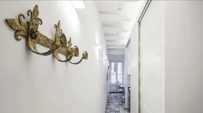 a hallway with gold metal hooks on the wall at Navona Hi-Tech Apartment in Rome