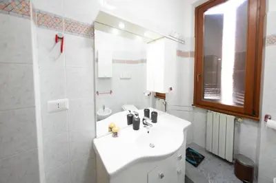 a white bathroom with a sink and a mirror at ROMA18 in Rome