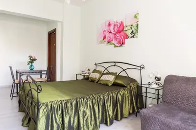 a bedroom with a bed and a chair and a couch at Floreo Guest House in Rome