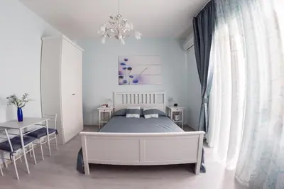 a bedroom with a bed and a table and a chandelier at Floreo Guest House in Rome