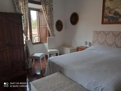 a bedroom with a bed and two chairs and a window at Catherine's Home in Rome