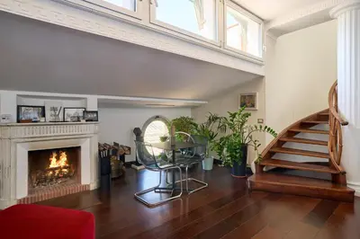 a living room with a fireplace and a staircase at La Mia Casa in Campo di Fiori in Rome