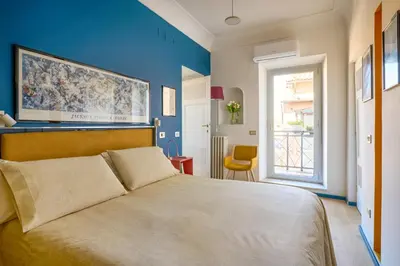 a bedroom with a large bed with a blue wall at La Mia Casa in Campo di Fiori in Rome