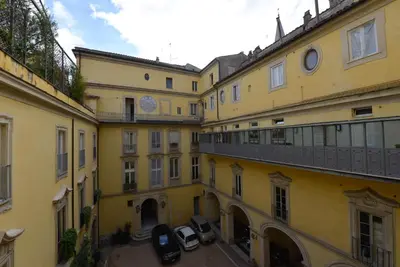 a group of buildings with cars parked in the courtyard at The Babuino - Luxury serviced apartment in Rome