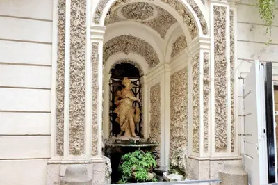 a statue of a woman sitting on top of a fountain at The Babuino - Luxury serviced apartment in Rome