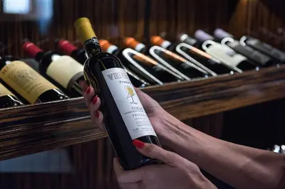 a woman holding a bottle of wine in front of a rack of wine bottles at The Babuino - Luxury serviced apartment in Rome