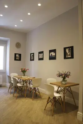 a room with tables and chairs and pictures on the wall at Roman Suite Guest House in Rome