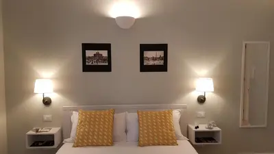 a bedroom with a bed with two lights on the wall at Roman Suite Guest House in Rome