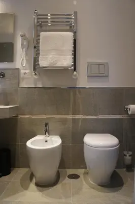a bathroom with a white toilet and a sink at Roman Suite Guest House in Rome