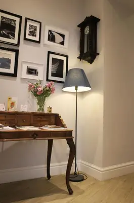 a table with a lamp and a clock on a wall at Roman Suite Guest House in Rome