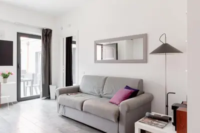 a living room with a couch and a mirror at Rhome Accomodation in Rome