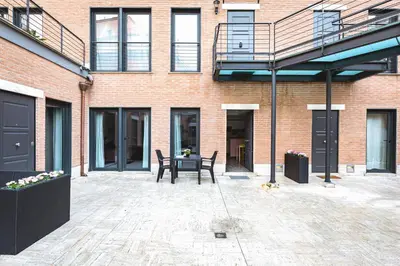 a patio with a table and chairs in front of a brick building at Rhome Accomodation in Rome