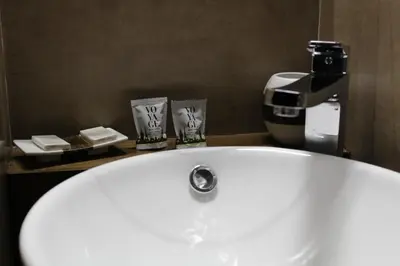 a bathroom with a white sink and a coffee maker at La Cupola Suite in Rome