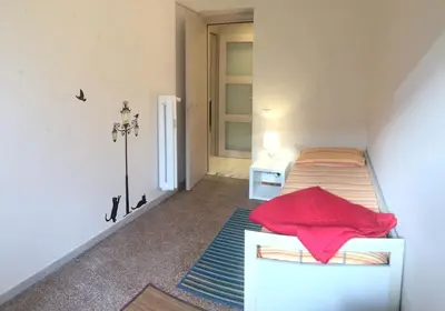 a bedroom with a bed with a red pillow on it at Lorenzo Magnifico Apartment in Rome