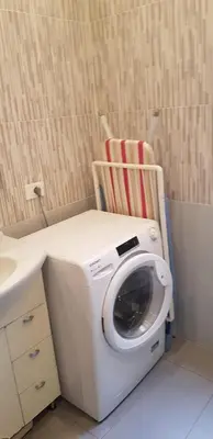 a washing machine sitting next to a sink and a chair at Lorenzo Magnifico Apartment in Rome