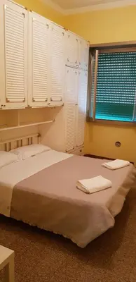 a bedroom with a bed and a window with white shutters at Lorenzo Magnifico Apartment in Rome