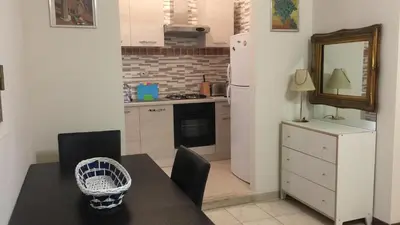 a kitchen with a dining table and a white refrigerator at Lorenzo Magnifico Apartment in Rome