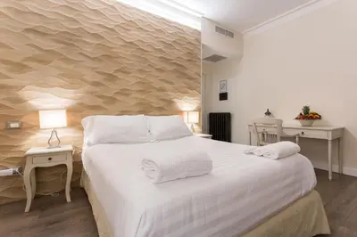 a bedroom with a large white bed and two tables at My Spanishsteps in Rome