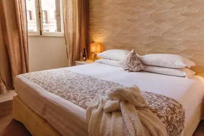 a bedroom with a large bed with pillows and a window at My Spanishsteps in Rome