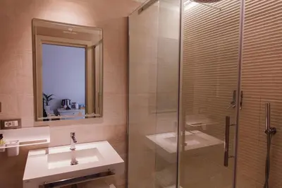 a bathroom with a sink and a glass shower at My Spanishsteps in Rome
