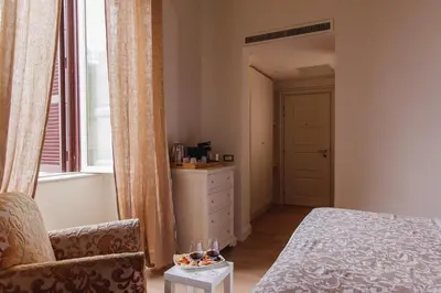 a bedroom with a bed and a chair and a window at My Spanishsteps in Rome