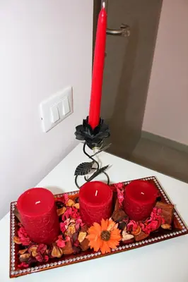 a red candle and three red cups on a table at Arcadia Domus in Rome