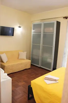 a living room with a couch and a yellow bed at Arcadia Domus in Rome