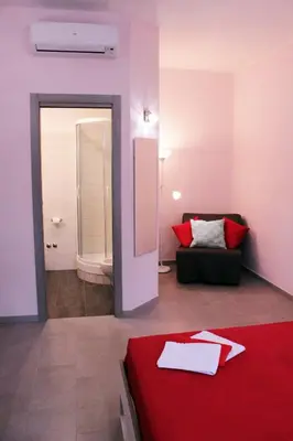 a room with a red bed and a couch at Arcadia Domus in Rome