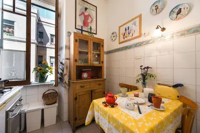 a kitchen with a table with a yellow table cloth at Colosseo Holiday House in Rome